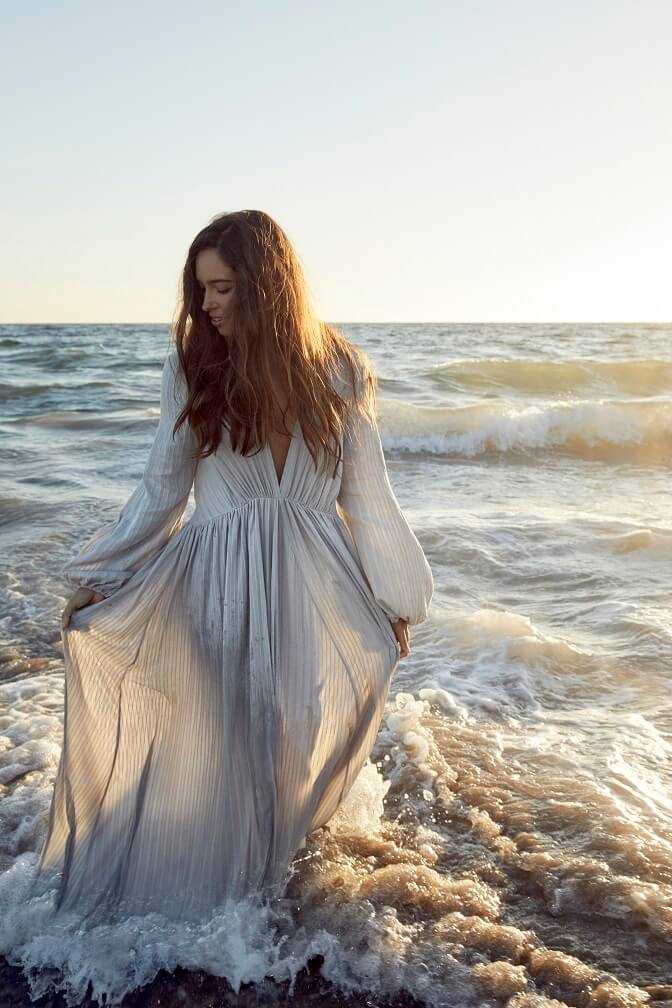Woman in long cotton dress in ocean
